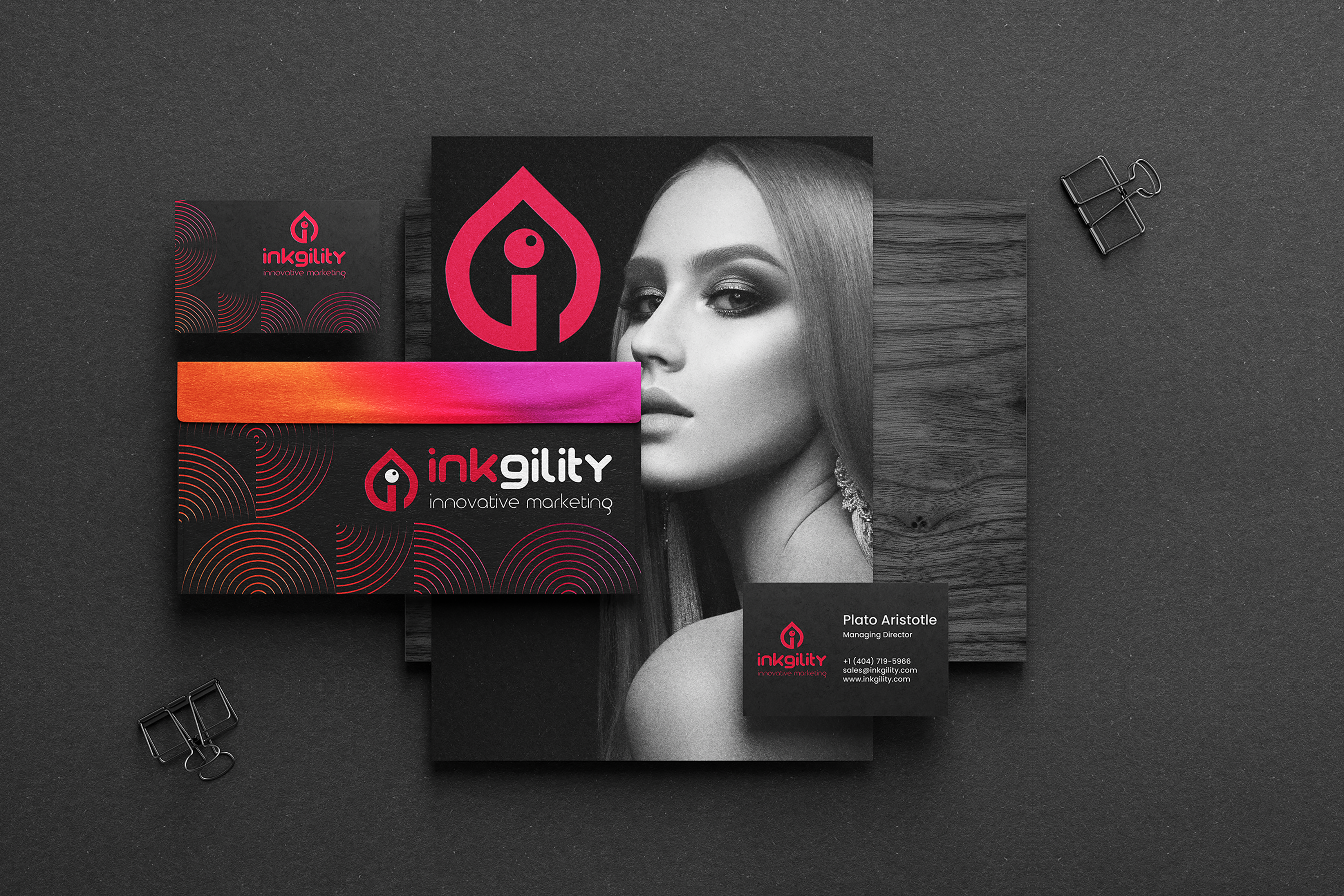 Inkgility dark stationery system on charcoal background: business cards, folded brochure with chess piece photography, envelope, wooden mount, box, and branded ribbon