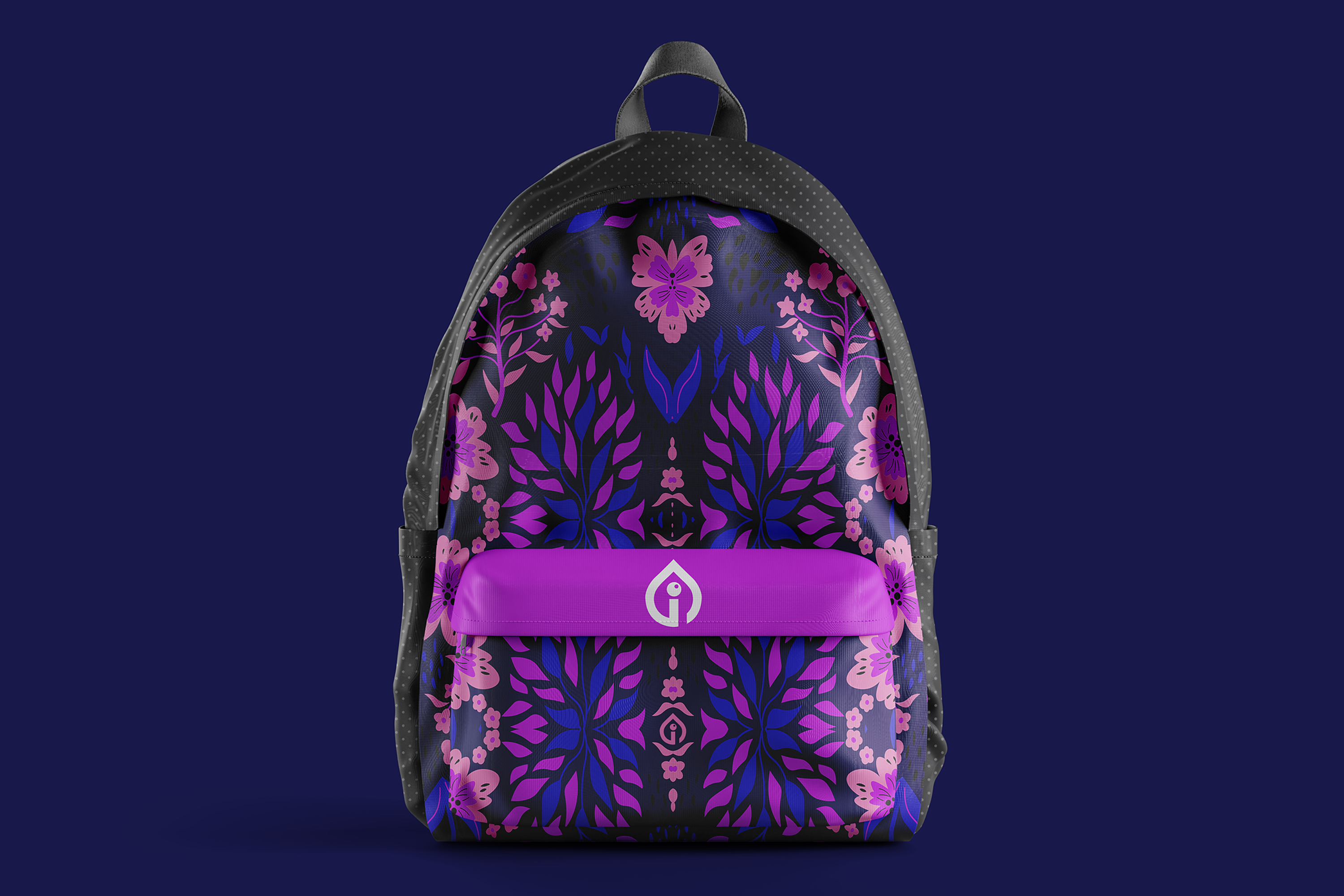 Backpack with all-over floral print in purple, magenta, and blue with the brand mark on a pink front pocket, photographed against a deep navy backdrop